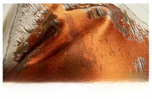 Macro detail of high-end orange jacquard fabric with vintage floral woven patterns