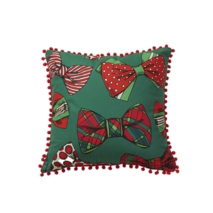 Green Christmas pillowcase with festive bow patterns and red pom-pom fringe edges