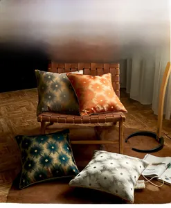 Detail of luxury cushion covers with metallic star prints in orange, green and silver gray