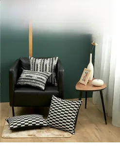 Detailed view of black and white geometric jacquard pillow covers on a dark sofa