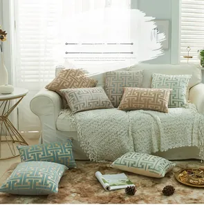 Close-up of chenille cushion covers with geometric Greek Key patterns on a soft sofa