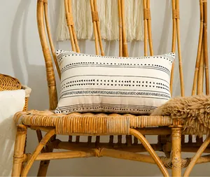Close-up of bohemian rectangle pillowcase with black geometric patterns on a rattan chair