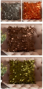 Detail of 3D leaf pattern satin pillow covers in grey, orange, bronze and olive green