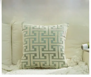 Close-up of geometric teal chenille throw pillow with jacquard texture on a sofa