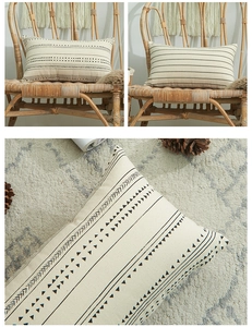 Detail view of boho cotton pillow covers with black geometric patterns on cream fabric