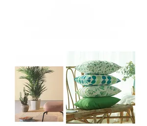 Détail de housses de coussin décoratives avec motifs de feuilles vertes et pois