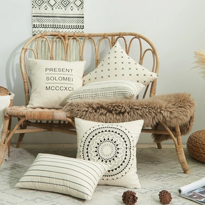 Minimalist cotton cushion covers with geometric mandala and letter prints in a cozy home setting