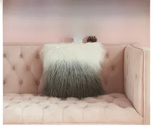 Detail of soft faux fur pillow case with gradient grey texture on a velvet sofa