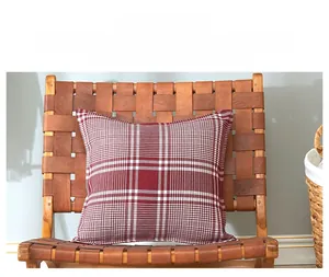 Detailed texture of a red and white checkered linen pillowcase on a leather chair