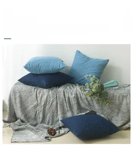 Close-up of modern denim blue pillow cover with textured knit fabric and square design
