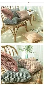 Detail of herringbone pattern woven pillow covers in burgundy brown black and orange