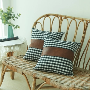 Minimalist black white gingham cushion cover with brown faux leather patch on rattan chair