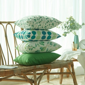 Lot de quatre housses de coussin à motif feuilles vertes sur une chaise vintage