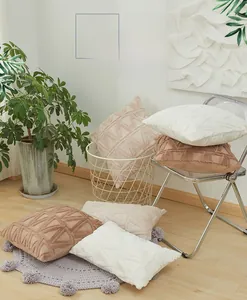 Detail of plush cushion cover with 3D geometric patterns in natural earth tones