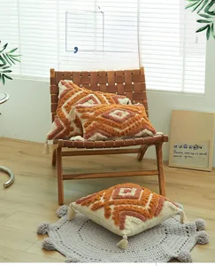 Detail of tufted geometric patterns and long tassels on a modern bohemian pillow cover