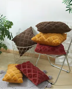 Detail of plush throw pillow cover with 3D geometric diamond texture in warm autumn tones