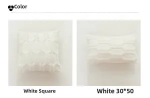 Detail view of white plush cushion covers with geometric 3D embroidery and soft texture