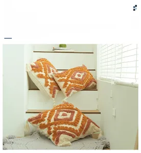 Close-up of bohemian tufted pillow cover with geometric patterns and corner tassels