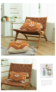 Detail of ethnic tufted pillow with orange geometric patterns and cream tassels