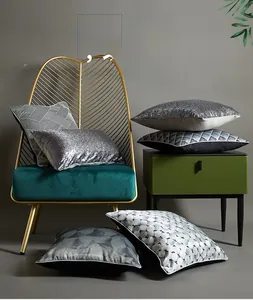 Detailed view of silver sequin and geometric textured cushion covers on a velvet chair