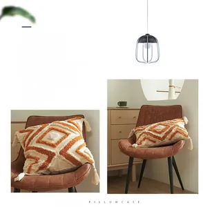 Détail de housse de coussin bohème à motifs géométriques tuftés avec des glands