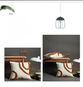 Close-up of textured denim pillowcase featuring orange tufted geometric embroidery