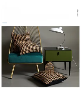 Close-up of yellow and black houndstooth tufted pillow covers on a velvet chair