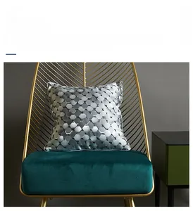 Detail of silver grey cushion cover with 3D honeycomb texture on modern green chair