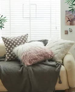 Detail of plush pillow covers with 3D wave textures and polka dots on a sofa