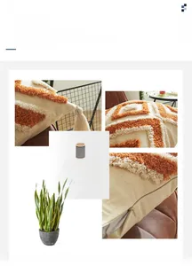 Détail des motifs géométriques tuftés et des glands sur la housse de coussin boho