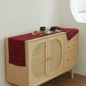 Classic red and green plaid table runner on a cream sideboard for cozy holiday decor