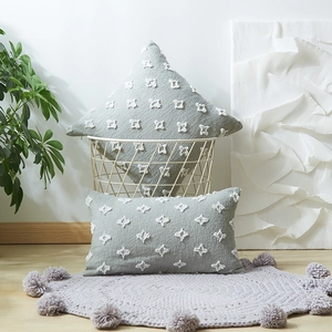 Sage green tufted star throw pillow covers on a white metal basket in a cozy home setting