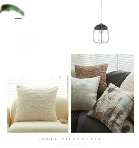 Gros plan sur le tissu pelucheux beige et les housses de coussin à motifs marbre