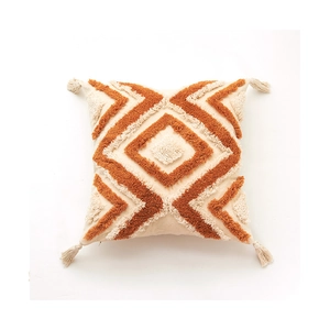 Housse de coussin bohème avec motifs géométriques tuftés orange et pompons sur blanc