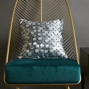 Silver grey geometric square cushion cover with glossy 3D hexagon pattern on velvet chair