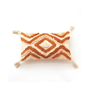 Coussin lombaire bohème avec motifs géométriques tuftés orange et pompons décoratifs