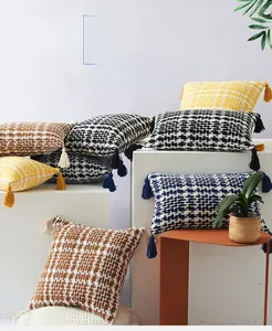 Macro detail of hand-woven cotton pillow cover with boho tassels and textured weave