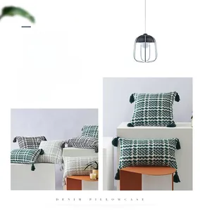 Detailed close-up of woven denim pillowcase with elegant corner tassels and rich texture