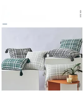 Close-up of woven pillows with decorative tassels and a textured 3D knit pattern