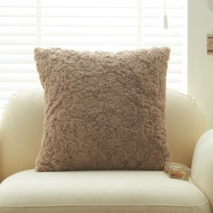 Housse de coussin moderne en fausse fourrure café clair sur canapé à texture bouclée