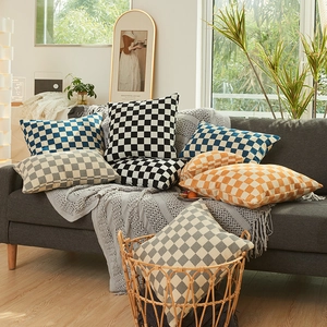 Moderne chenille kussens met schaakbordpatroon in diverse kleuren op grijze bank