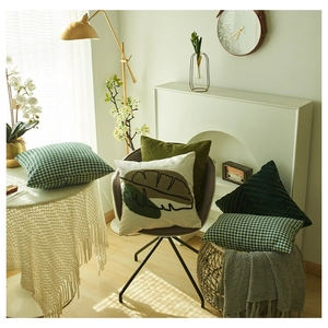 Detail of Nordic style green textured cushions with velvet pleats and knit patterns