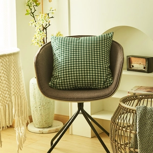Nordic houndstooth throw pillow cover in green and white on a modern armchair