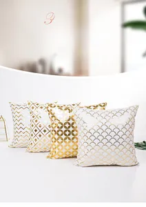 Detail showing four geometric gold foil patterns on white pillow covers with wave and scales
