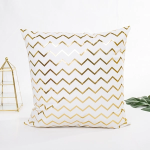 Minimalist white pillow cover with golden metallic zigzag patterns in a modern style