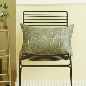 Italian luxury geometric jacquard pillow cover in olive green and silver on a metal chair