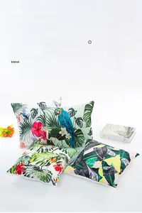 Detailed close-up of tropical palm leaf and parrot prints on silk satin pillow covers