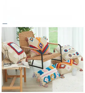 Macro detail of bohemian tufted cushion cover with colorful tassels and geometric patterns