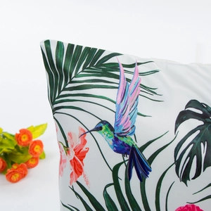 Tropical style pillowcase featuring vibrant hummingbird and green palm leaves on white fabric