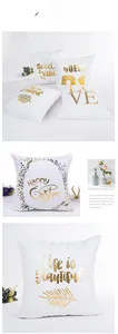 Detail of white throw pillow with golden foil lettering and palm leaf patterns